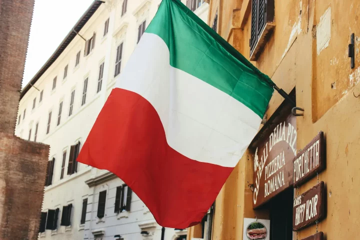 Foto da bandeira da Itália pendurada em frente a um estabelecimento em Roma