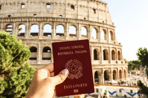 Cidadania Italiana: Foto de pessoa mostrando seu passaporte em frente ao Coliseu