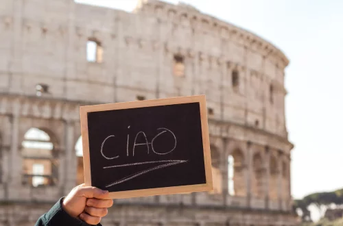 como-dizer-oi-em-italiano Como dizer oi em italiano: Foto de uma placa escrito "ciao" em frente ao Coliseu de Roma
