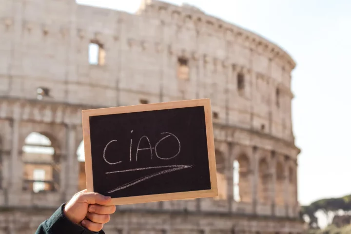 como-dizer-oi-em-italiano Como dizer oi em italiano: Foto de uma placa escrito "ciao" em frente ao Coliseu de Roma