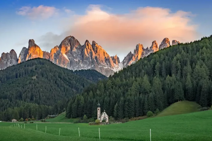 Corte Constitucional o futuro da cidadania italiana por descendência: Foto de uma igreja em frente os picos das Dolomitas