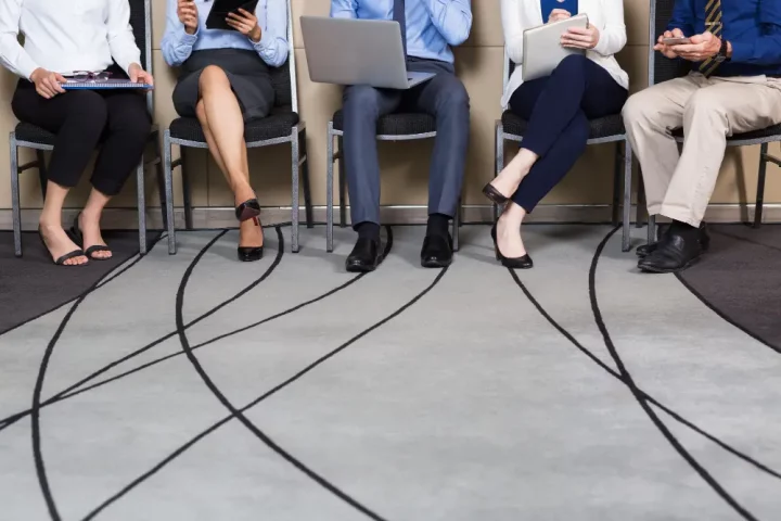 Pessoas sentadas na fila de espera do consulado italiano