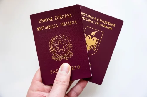 Foto de uma pessoa segurando um passaporte italiano e um albanês