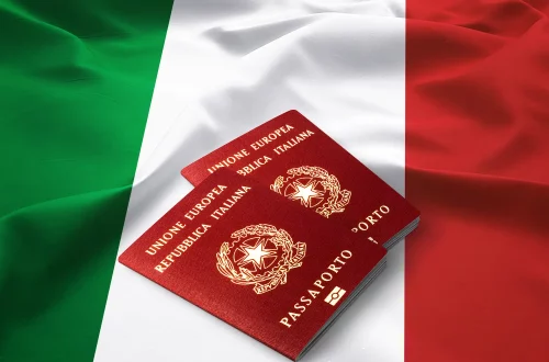 Foto de dois passaportes italianos no topo de uma bandeira da Itália