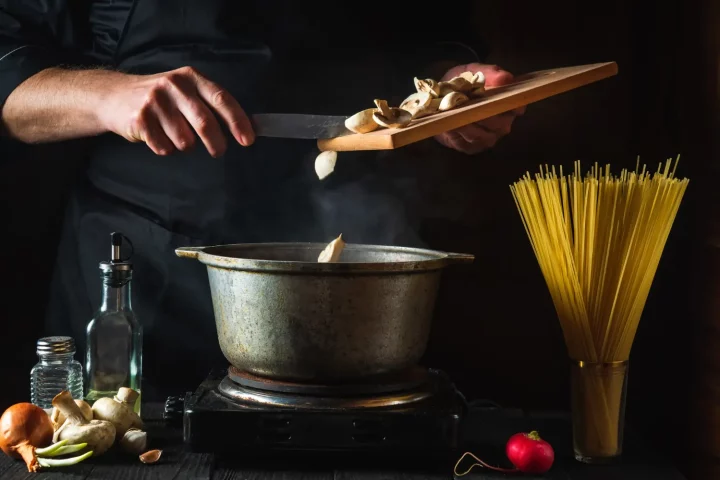 Os 10 pratos italianos mais amados no Brasil e suas histórias: Foto de um cozinheiro italiano preparando comida