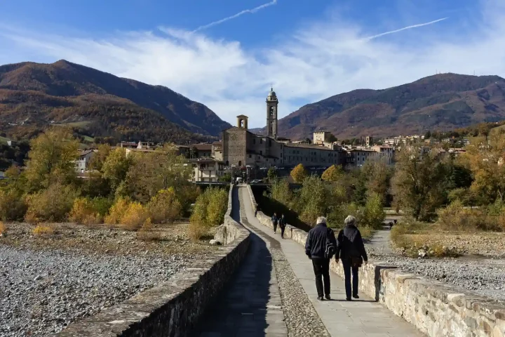 Regras da cidadania italiana por casamento em 2025: Foto de casais passeando na Ponte Gobbio, na comuna de Bobbio.