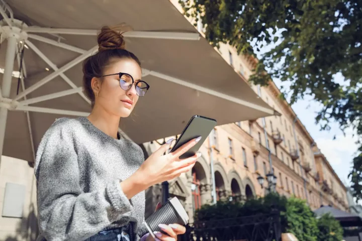 Visto de nômade digital para a Itália: Foto de uma mulher acessando seu celular na Itália